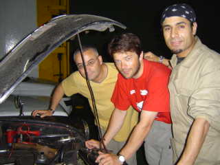 Tim checks the oil on the ferry watched by Boussad and Hakim 